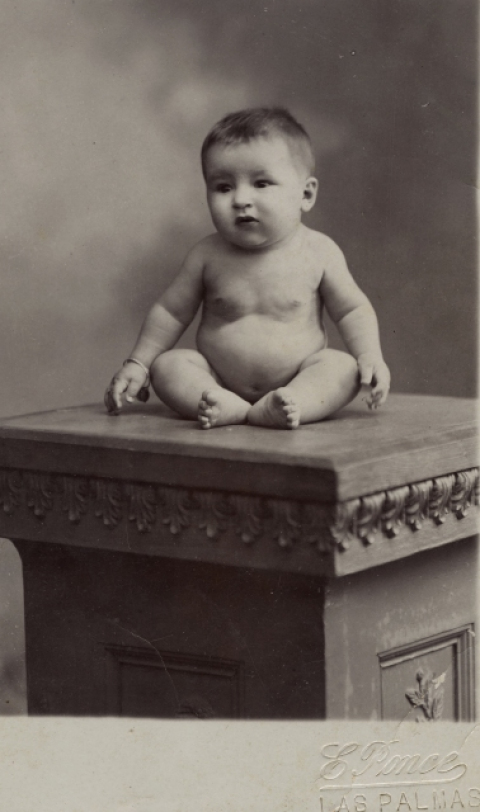 BEBE DESNUDO SOBRE MUEBLE