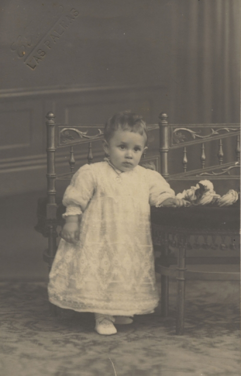 NIÑO DE PIE JUNTO A CUNA
